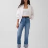 Dżinsy z wysokim stanem i podwiniętymi nogawkami, o prostym kroju typu slim w stylu lat 90.