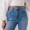 Dżinsy z wysokim stanem i podwiniętymi nogawkami, o prostym kroju typu slim w stylu lat 90.